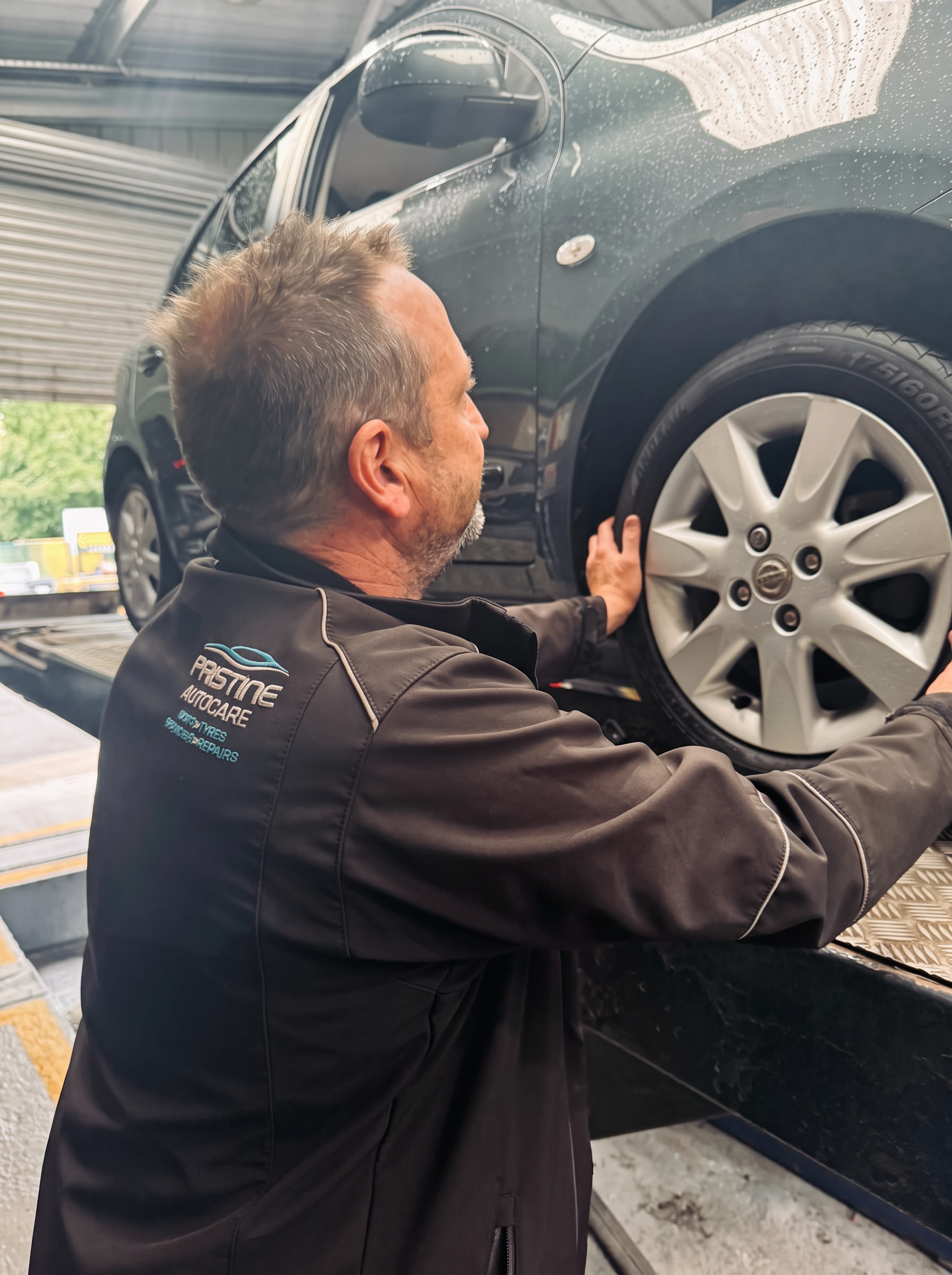 Pristine Autocare mechanic working on a tyre